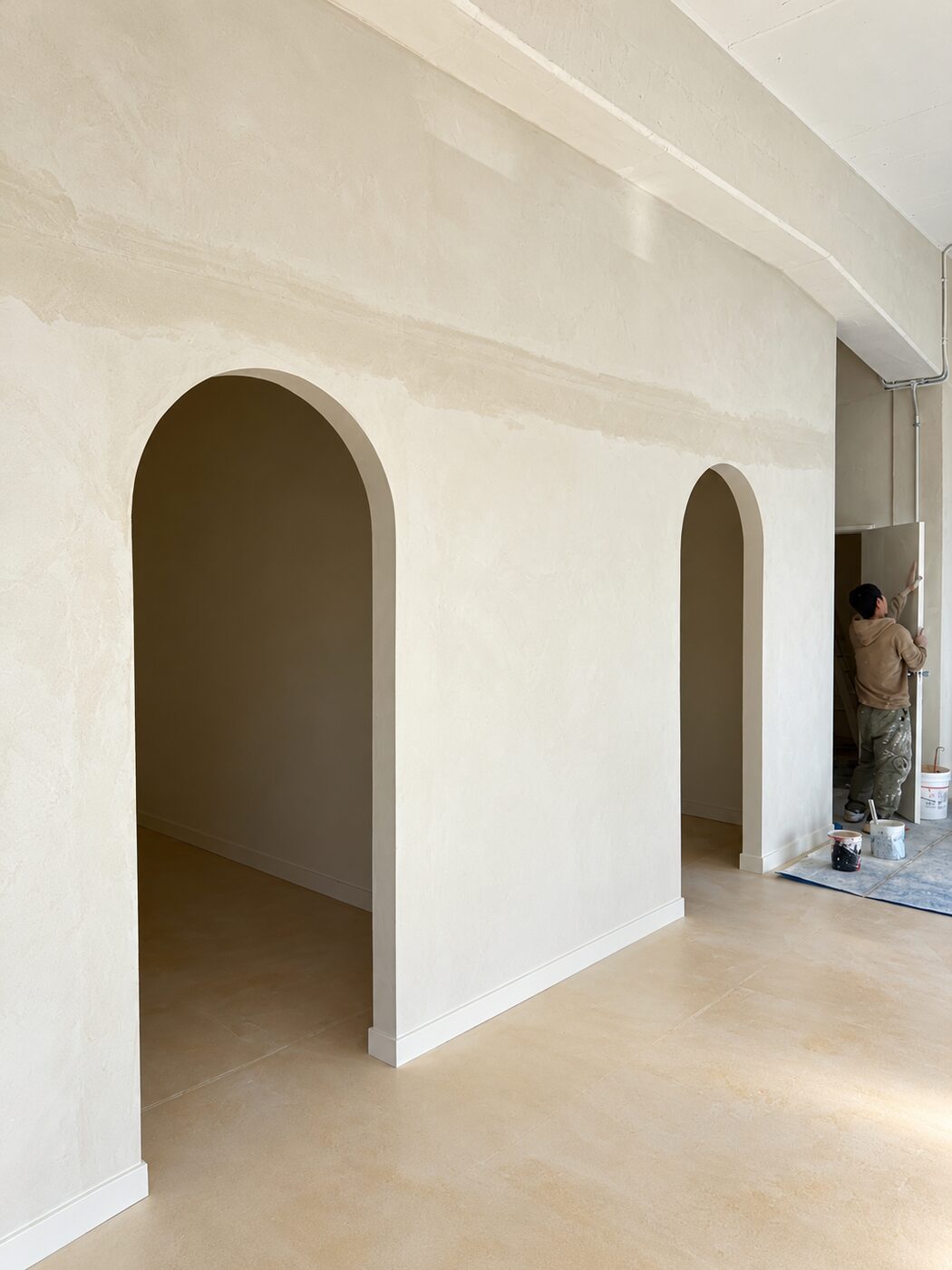 Hand-finished plaster wall with twin arched openings